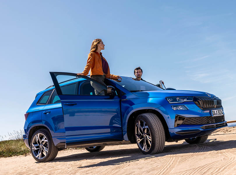 Schmolck Garantie-Paket, auf dem Bild sieht man eine Frau und einen Mann auf der Türleiste einer Skoda Karoqs stehen